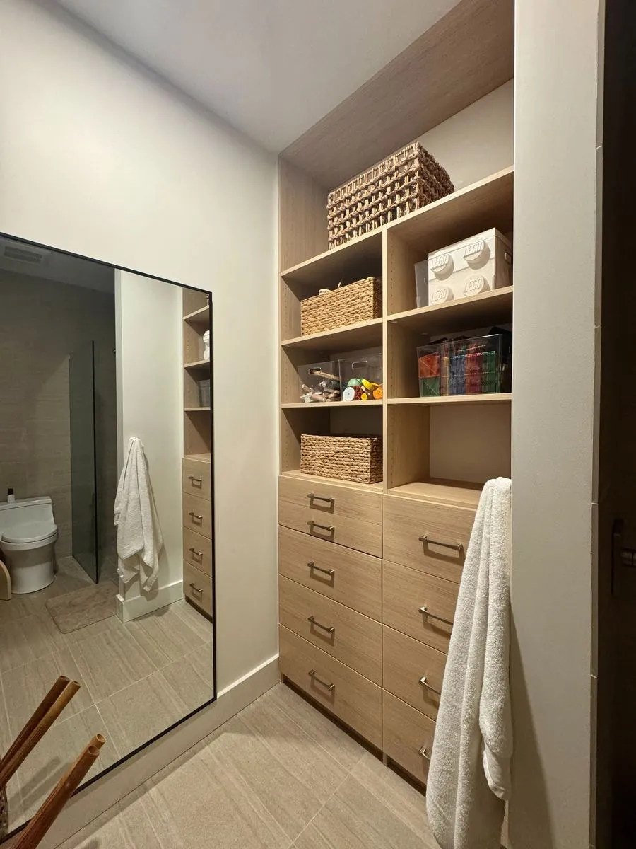 Oak linen closet with drawers near bathroom
