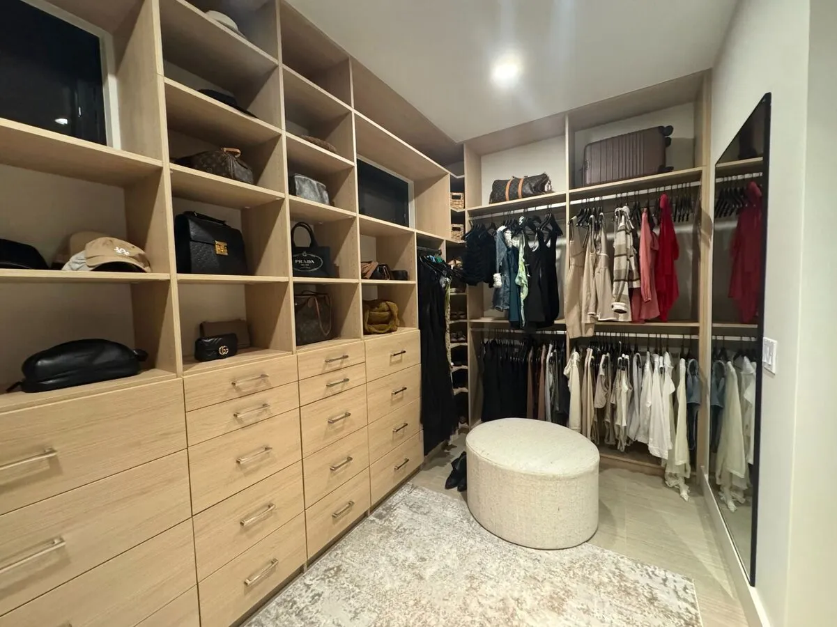 Natural oak walk-in closet with drawer cubbies and hanging storage