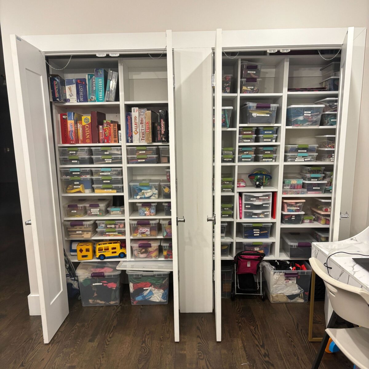 Playroom storage closets with board games and craft bins