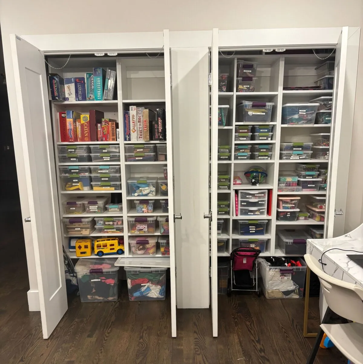 Playroom storage closets with board games and craft bins
