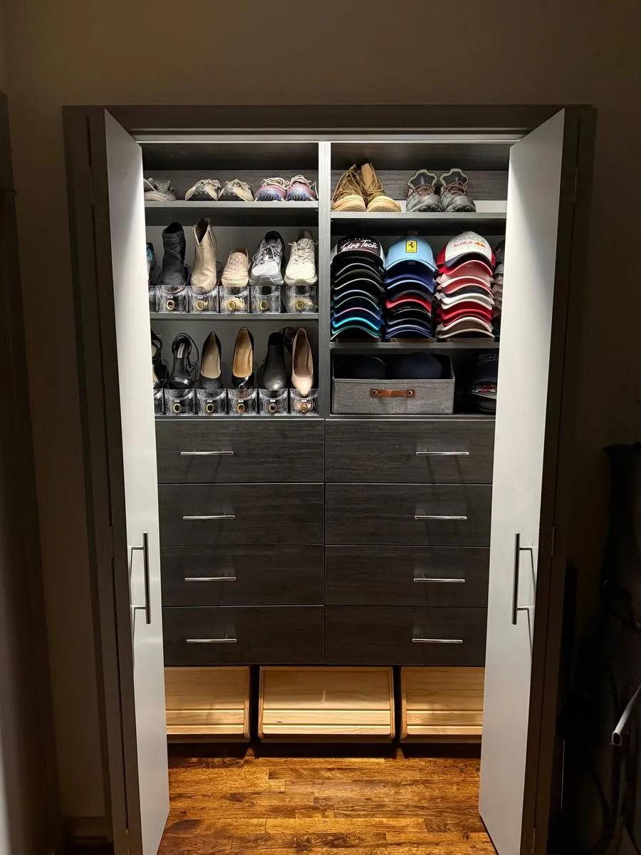 Gray reach-in closet with shoe shelves, hat storage and LED lighting
