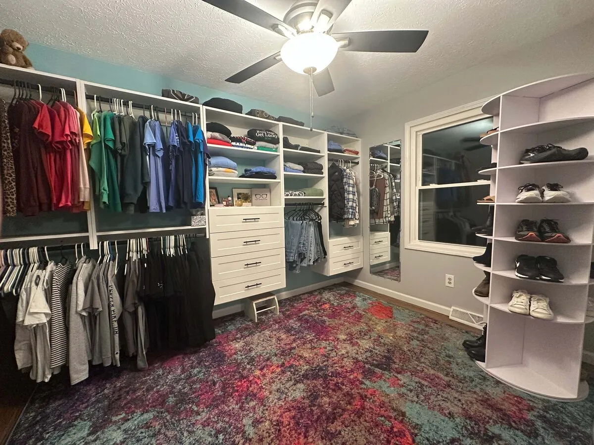 Room converted to walk-in closet with corner curved shoe shelves