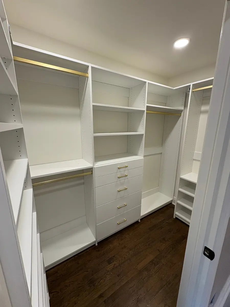 Walk-in closet with gold rods and hardware