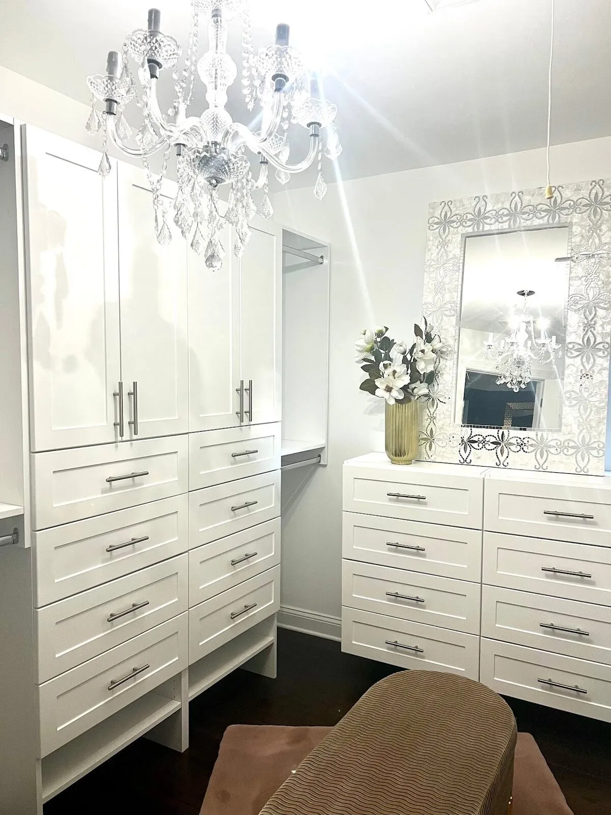 White walk-in closet with chandelier mirror and floor-to-ceiling drawers